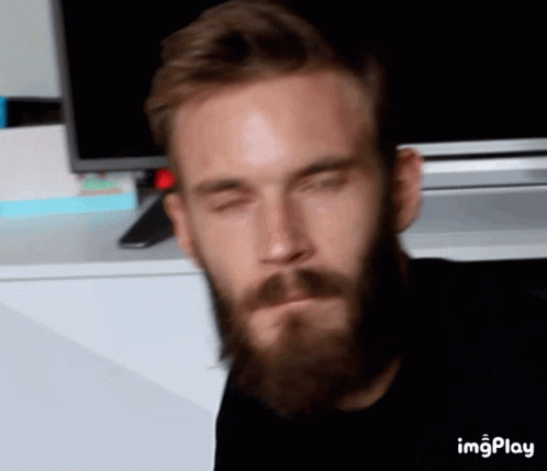 A Man With A Beard Has His Eyes Closed In Front Of A Tv And A Screen That Says Imgplay On It GIF