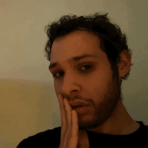 a man with a beard has his hand on his chin