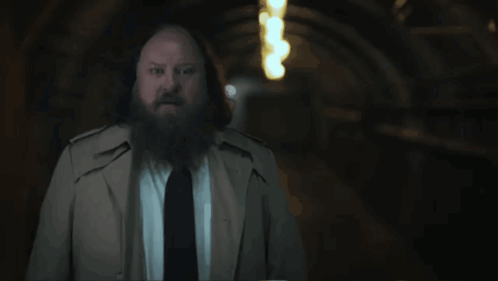A Man With A Beard In A Trench Coat And Tie Says " That 'S What We Call A Mystery " GIF