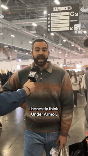 A Man With A Beard Is Being Interviewed At A Convention GIF