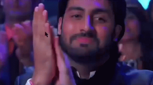 A Man With A Beard Is Clapping His Hands In Front Of A Computer Mouse . GIF