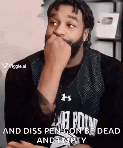 A Man With A Beard Is Covering His Mouth With His Hand While Wearing A Black Under Armour Shirt . GIF