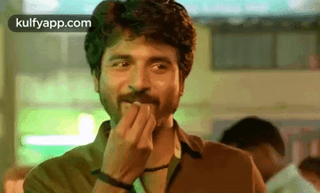 A Man With A Beard Is Covering His Mouth With His Hands . GIF