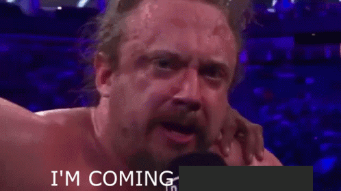 A Man With A Beard Is Crying In Front Of A Microphone With The Words I 'M Coming Written Below Him GIF
