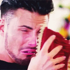 A Man With A Beard Is Crying While Holding A Red Towel GIF