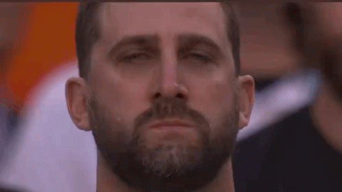 A Man With A Beard Is Crying With His Eyes Closed And A Tear Coming Out Of His Nose . GIF