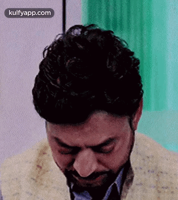 A Man With A Beard Is Crying With His Eyes Closed In A Room . GIF
