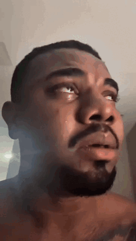 A Man With A Beard Is Crying With Tears Coming Out Of His Eyes . GIF
