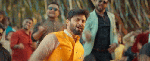 A Man With A Beard Is Dancing In Front Of A Crowd . GIF