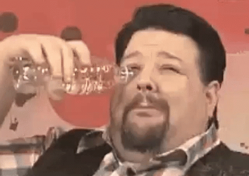 A Man With A Beard Is Drinking From A Bottle Of Water . GIF