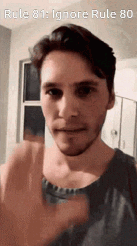 A Man With A Beard Is Giving A Thumbs Up In Front Of A Sign That Says Rule 81 : Ignore Rule 80 GIF