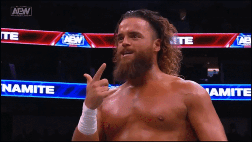 a man with a beard is giving the middle finger in front of a sign that says namite