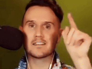 A Man With A Beard Is Giving The Middle Finger While Wearing Headphones And A Microphone . GIF