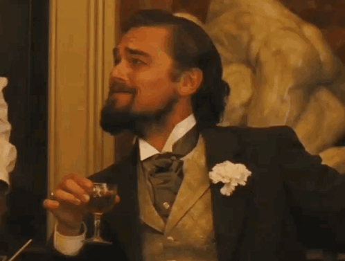 A Man With A Beard Is Holding A Glass Of Wine GIF