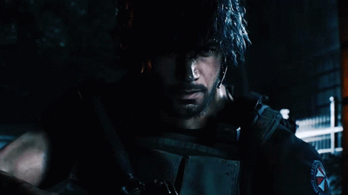 A Man With A Beard Is Holding A Gun In A Dark Room GIF