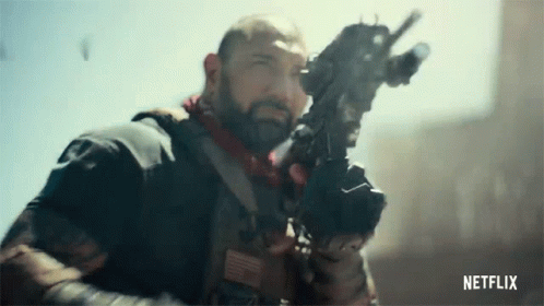 A Man With A Beard Is Holding A Gun In His Hand In A Netflix Trailer . GIF
