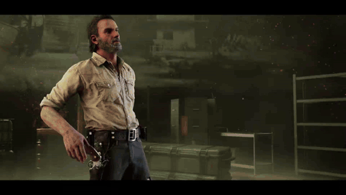 A Man With A Beard Is Holding A Gun In His Right Hand GIF