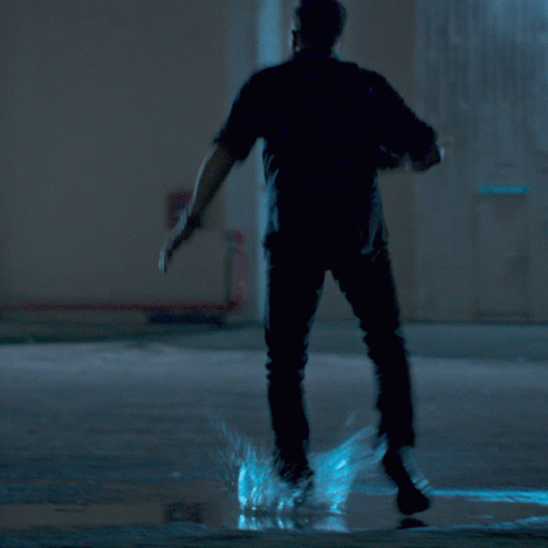 A Man With A Beard Is Holding A Gun In His Right Hand GIF