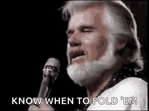 A Man With A Beard Is Holding A Microphone And Singing . GIF
