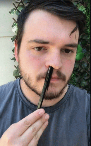 A Man With A Beard Is Holding A Pen In His Hand GIF