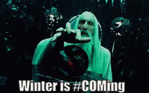 A Man With A Beard Is Holding A Red Ball With The Words Winter Is # Coming Below Him GIF