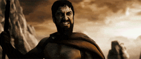 A Man With A Beard Is Holding A Spear In His Hand GIF