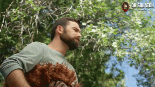 A Man With A Beard Is Holding A Stuffed Animal That Says Dr Squatch GIF