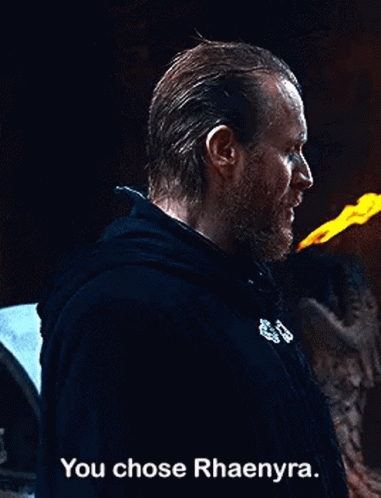 a man with a beard is holding a torch in his hand and says `` you chose rhaenyra . ''