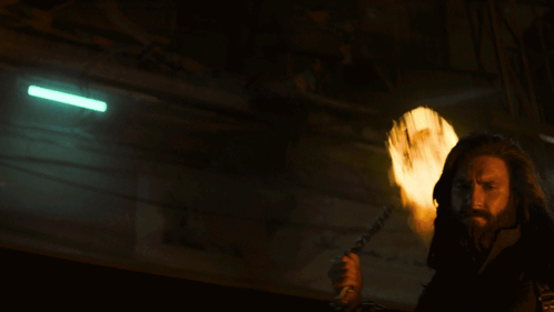 A Man With A Beard Is Holding A Torch In His Hand GIF