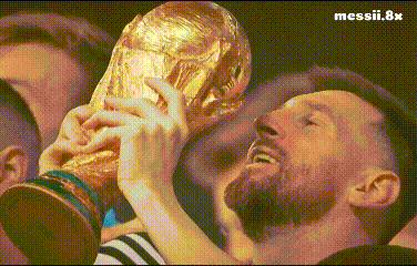 A Man With A Beard Is Holding A Trophy In His Hands In Front Of A Crowd . GIF