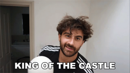 A Man With A Beard Is Holding A White Ball With The Words King Of The Castle Above Him GIF
