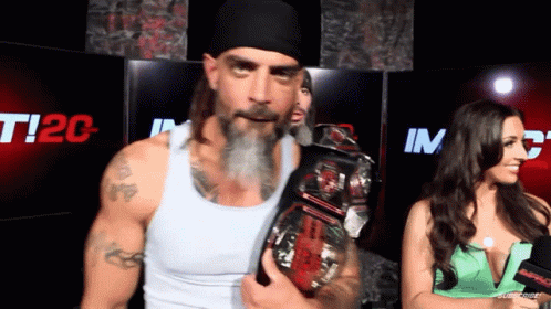 a man with a beard is holding a wrestling championship belt