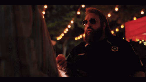A Man With A Beard Is Holding An Apple And The Words Trick Or Treat Are Below Him GIF