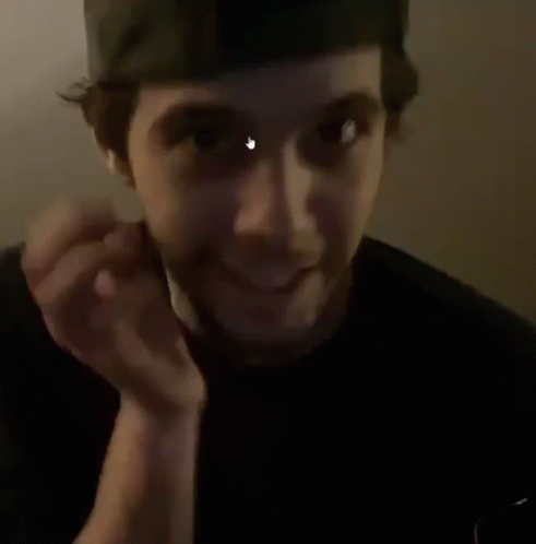 A Man With A Beard Is Holding His Hand To His Chin And Making A Face . GIF