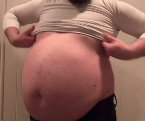 Man With Beard Holding Stomach In White Shirt GIF