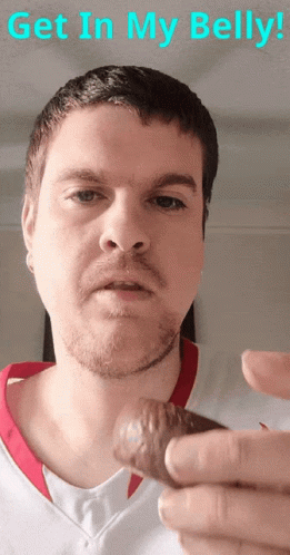 A Man With A Beard Is Holding Something In His Hand With The Words Get In My Belly Written Above Him GIF