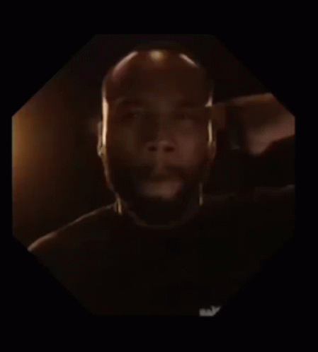 A Man With A Beard Is In A Dark Room GIF