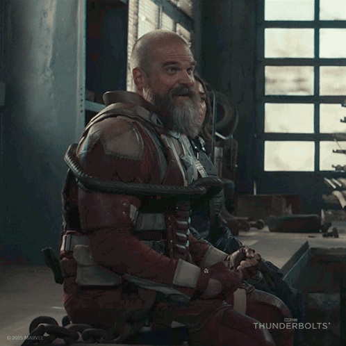 A Man With A Beard Is Laughing While Sitting In A Wheelchair GIF