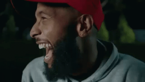 A Man With A Beard Is Laughing With His Eyes Closed And His Mouth Open . GIF