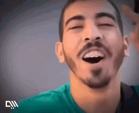 A Man With A Beard Is Laughing With His Eyes Closed . GIF