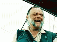 A Man With A Beard Is Laughing With His Mouth Wide Open GIF