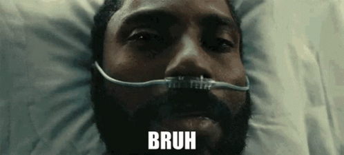 A Man With A Beard Is Laying In A Hospital Bed With An Oxygen Mask On His Face And The Word Bruh Above Him . GIF