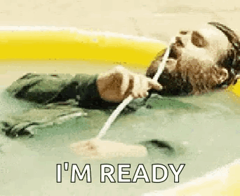 A Man With A Beard Is Laying In A Pool Of Water Drinking Water Through A Straw . GIF