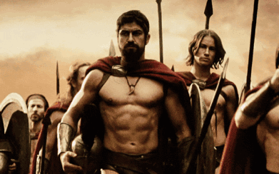 A Man With A Beard Is Leading A Group Of Men With Spears And Shields GIF