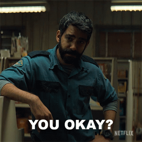 A Man With A Beard Is Leaning Against A Counter And Says You Okay GIF