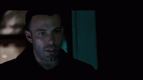 A Man With A Beard Is Looking At Something In The Dark GIF