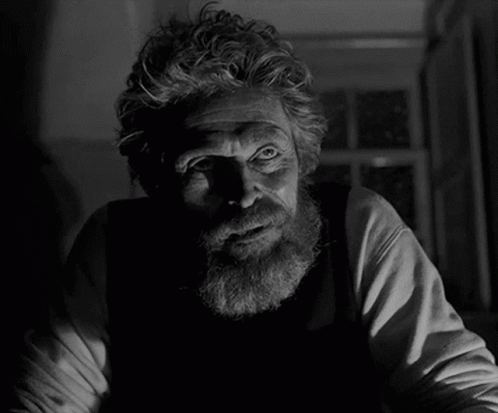 A Man With A Beard Is Looking At The Camera In A Black And White Photo GIF