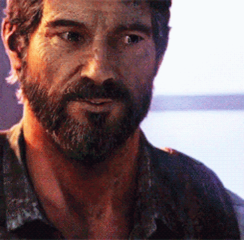 A Man With A Beard Is Looking At The Camera With A Lake In The Background . GIF