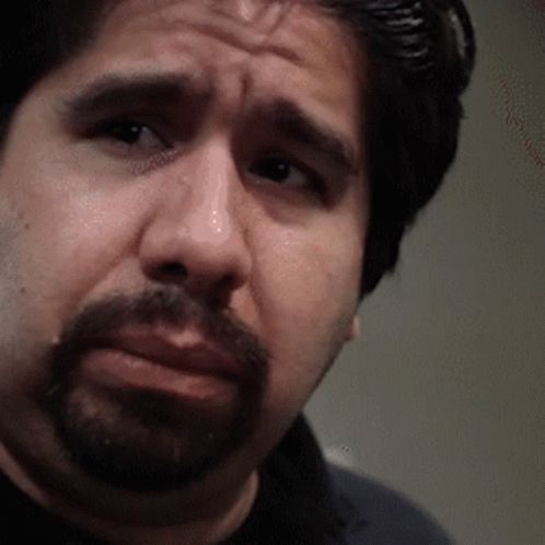A Man With A Beard Is Looking At The Camera With A Serious Look On His Face GIF