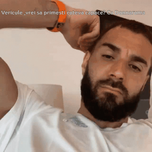 A Man With A Beard Is Looking At The Camera With The Caption Vericule Vrei Sa Primesti Cateva Capace GIF